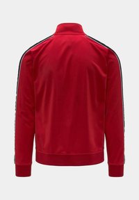 Giacca sportiva rossa con colletto alto, maniche lunghe e strisce nere sulle spalle. Tessuto liscio e design aderente.