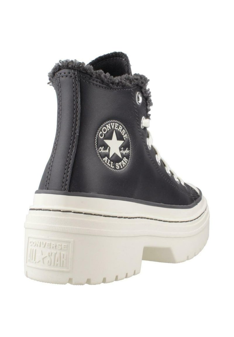 Schwarzer hoher Converse All Star-Stiefel mit weißer dicker Sohle, weißen Schnürsenkeln, sichtbarem Logoaufnäher und pelzgefüttertem Kragen.