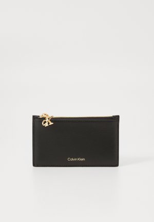 Portafoglio in pelle nera con zip dorata e logo, caratterizzato da un design rettangolare elegante e dettagli minimalisti.
