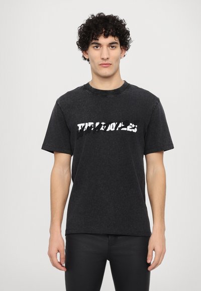 Black cotton t-shirt with a relaxed fit, featuring a distressed white graphic print across the chest and short sleeves.