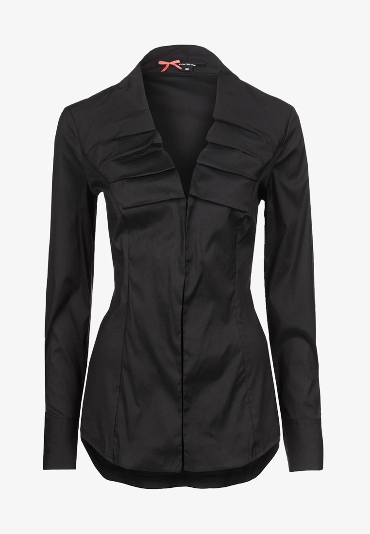 Blouse noire cintrée à manches longues avec un large col doté de détails plissés superposés sur le devant.