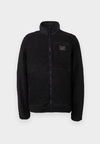 Melna zip-up vilnas jaka ar teksturētu, pūkainu virsmu, stāvošu apkakli un krūšu kabatu ar zīmola birku.