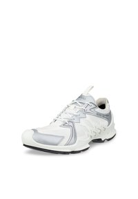 Λευκό και γκρι αθλητικό παπούτσι χαμηλού προφίλ με ύφασμα από δίχτυ, κορδόνια, υφή στην σόλα και θηλιά στο πίσω μέρος.