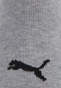 Gray knit fabric with a black Puma logo, depicting a leaping puma, centered on the material.
