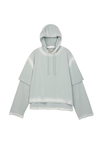 Jasnoszara, warstwowa bluza z kapturem, z długimi rękawami i sznurkami do regulacji, krótki krój i oversize'owy fason na białym tle.