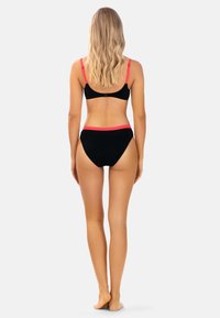 Czarny strój kąpielowy składający się z topu z różowymi ramiączkami i dopasowanym pasem. Tkanina jest gładka, a wzór minimalistyczny.