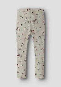 Beżowe legginsy dziecięce z rozproszonym wzorem małych grzybów i kwiatów w stonowanych odcieniach brązu, purpury i niebieskiego.
