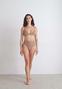 Svijetlosmeđi bikini set s glatkim braletom s tankim naramenicama i visokim donjim dijelom s suptilnom rebrastom teksturom.