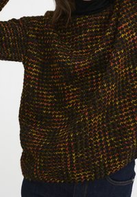 Maglione lavorato a maglia con un motivo testurizzato multicolore in tonalità di nero, arancione e giallo. Vestibilità ampia e scollatura rotonda.