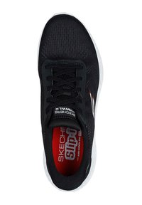 Zapatilla deportiva negra con parte superior de malla transpirable, superficie texturizada, entresuela blanca y plantilla roja con branding en blanco.