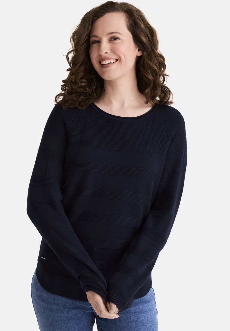 Marineblauer Strickpullover mit horizontalen Streifen, Rundhalsausschnitt und langen Ärmeln. Weiche Textur mit lockerer Passform und einem kleinen seitlichen Etikett.
