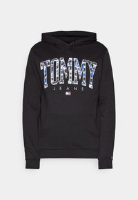 Sudadera de algodón negra con bolsillo canguro, con un llamativo estampado de "TOMMY" en un patrón multicolor y "JEANS" en blanco, capucha ajustable con cordón.