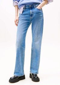 Jeans azzurri a gamba dritta in tessuto denim, con vita alta, tasche frontali e finitura leggermente sbiadita. Abbinati a stivaletti platform neri.