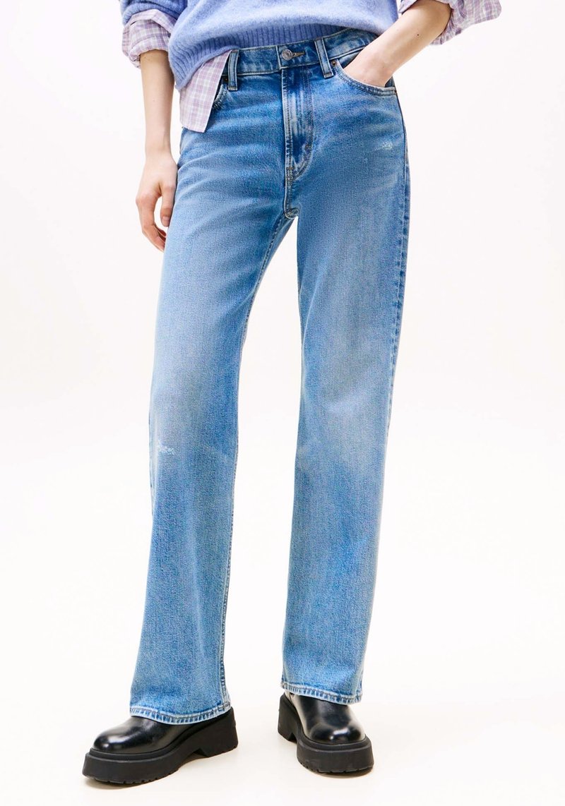 Jeans azzurri a gamba dritta in tessuto denim, con vita alta, tasche frontali e finitura leggermente sbiadita. Abbinati a stivaletti platform neri.