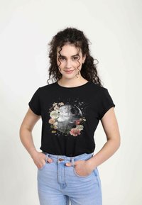 Sort t-shirt med grafik af Dødsstjernen omgivet af farverige blomster mønstre. Korte ærmer og en afslappet pasform.