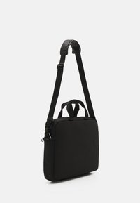 Svart laptopveske med rektangulær form, laget av stoff. Har to håndtak på toppen og en justerbar skulderstropp. Minimalistisk design.