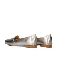 Metallische zilveren ballerina's met een ronde neus, platte houten hak en een gladde textuur. Eenvoudig ontwerp zonder zichtbare hardware of versieringen.