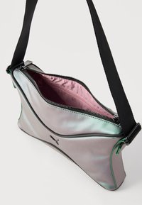 Μικρή ιριδίζουσα γκρι τσάντα ώμου με μαύρο φερμουάρ, ροζ εσωτερική επένδυση και ρυθμιζόμενο μαύρο λουρί σε λευκό φόντο.