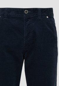 Marineblauwe corduroy broek met een soepele textuur, ritssluiting en een enkele knoopsluiting. Voorzien van riemlussen en metalen accenten bij de zakken.