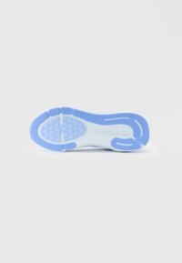 Suela de una zapatilla deportiva en azul claro y blanco que muestra un patrón de agarre texturizado y detalles de banda de rodadura curva sobre un fondo blanco.