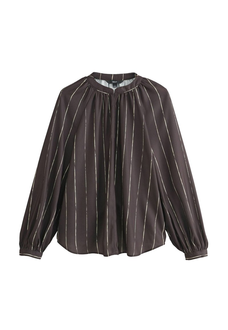 Blouse marron foncé avec des rayures verticales blanches, à manches longues et avec des détails plissés sous le col. Tissu doux et léger.