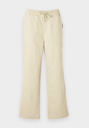 Μπεζ παντελόνι φαρδύ με ελαστική μέση και κορδόνι, διαθέτει δύο τσέπες εμπρός και ίσια γραμμή στα πόδια.