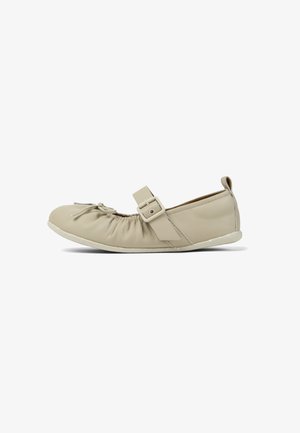 Beige platte Mary Jane-schoen met elastische geplooide voorkant, verstelbare gespsluiting en afgeronde neus, ontworpen voor casual gebruik.