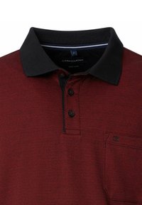 Czerwona koszulka polo z czarnym kołnierzykiem, o fakturowanym wzorze, z trzema guzikami przy szyi oraz małą kieszonką na piersi. Widoczna metka marki.