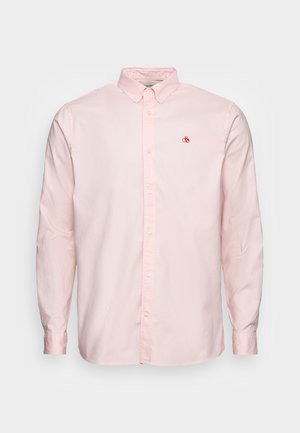 Chemise rose clair à manches longues, boutonnée, avec col boutonné et petit logo rouge brodé sur la poitrine gauche.