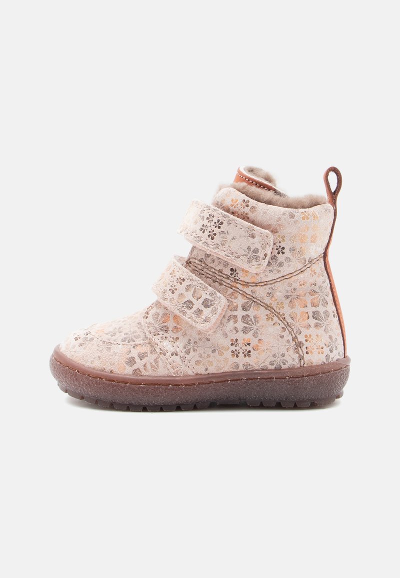 Bottine à lacets en matériau à motif rose clair avec design floral, deux sangles Velcro réglables et une semelle en caoutchouc marron.