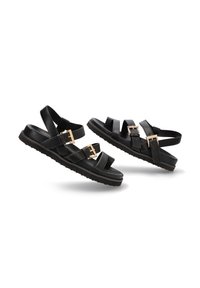 Sandalias negras con múltiples correas mate, que cuentan con hebillas en tono dorado. Una suela texturizada proporciona agarre y comodidad. Diseño elegante y moderno.