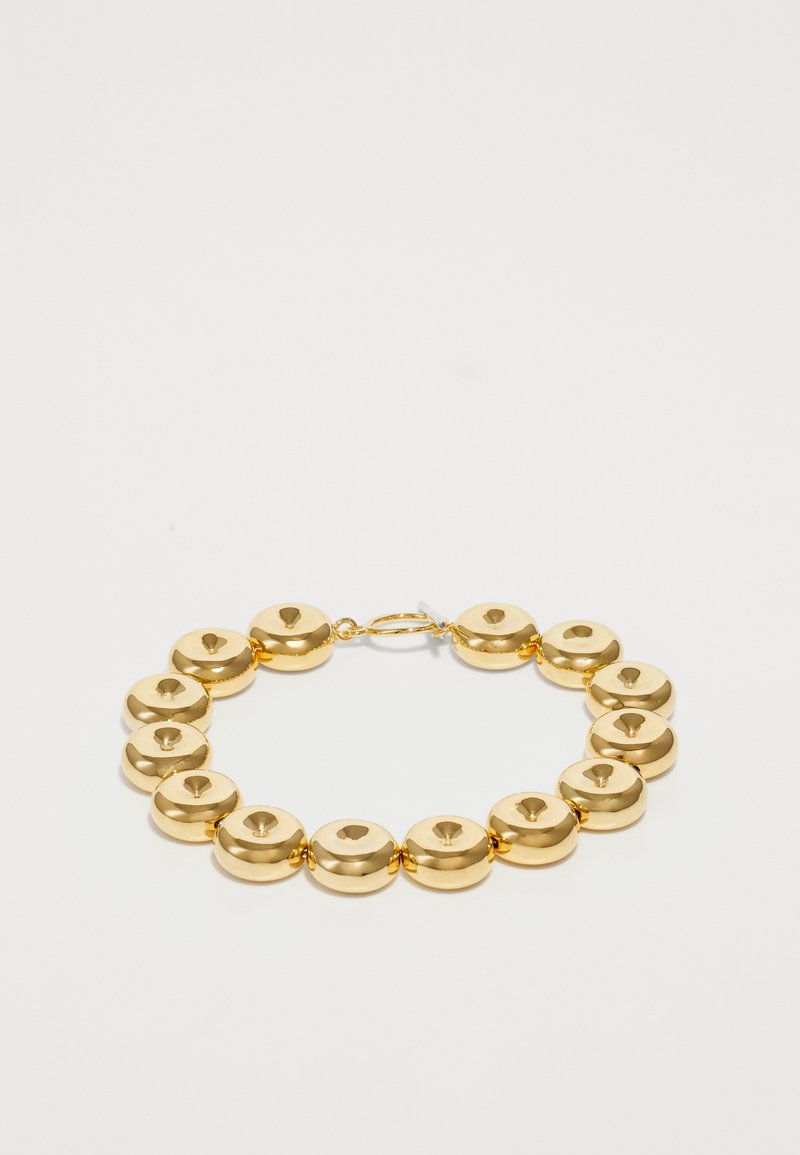 Bracciale d'oro composto da dischi rotondi e lisci, equidistanti, ognuno con un foro centrale. Presenta una semplice chiusura per la chiusura.