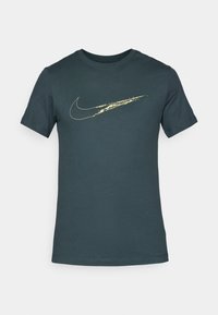 Temno zelena bombažna majica s kratkimi rokavi in okroglo ovratnikom; na sprednjem delu je zlat logotip Nike. Gladka tekstura.