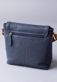 Navy leather bag with a roll-top and zippered front pocket. Features contrasting brown accents and visible stitching. Smooth texture.