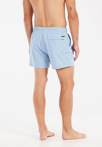 Svetlomodré plavky s elastickým pásom, zadnou vreckom a plochými švami, navrhnuté pre pohodlie a pohyblivosť.