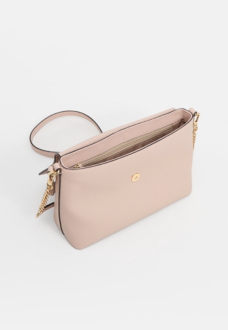 Borsa a mano in pelle rosa chiaro con una finitura liscia, hardware dorato e chiusura con zip. Ha una lunga tracolla e una tasca interna.