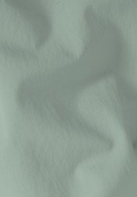 Texturierter Stoff in sanftem Mintgrün, mit sanften Wellen und einem dezenten Glanz, auf dessen Oberfläche ein feines Rippenmuster sichtbar ist.