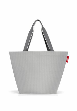 Graue Stofftragetasche mit strukturiertem Design, breiten grauen Trägern und einem roten Logoetikett, mit vertikaler Rillente texture und ohne sichtbare Hardware.
