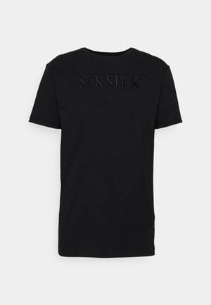 Sort kortærmet t-shirt med rund hals og hævet sort "SIKSILK" logo samt dekorativt emblem på brystet, præsenteret mod en hvid baggrund.