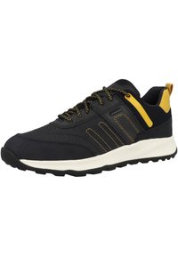 Zapato deportivo negro con parte superior texturizada, acentos amarillos y cordones con estampado. Presenta una suela de goma blanca para mayor tracción.