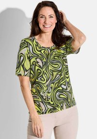 Korte mouwen blouse met een groen, geel en beige abstract draaipatroon, met een ronde halslijn en een zachte stoftextuur.