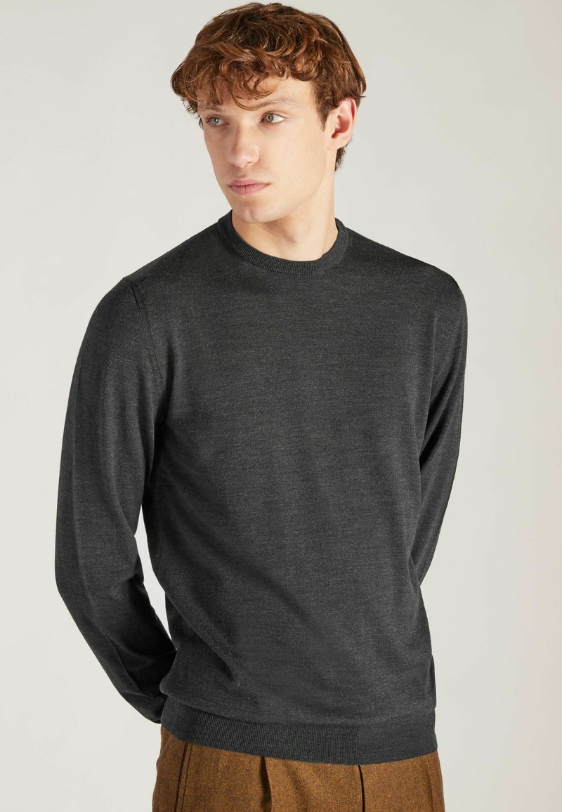 Dunkelgrauer Langarmpullover mit rundem Ausschnitt und gerippten Bündchen. Hergestellt aus einem glatten, weichen Stoff mit minimaler Textur.