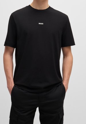 Black T-shirt in soft fabric with a classic round neckline. Features a subtle white "BOSS" logo at the center chest.