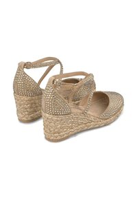 Beige wiggen sandalen met een geweven jute zool, met een bovenwerk van suède versierd met zilveren strass-steentjes en kruislings enkelbandjes.