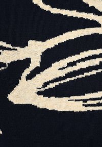 Strickstoff mit einem dunklen Marineblau-Hintergrund und kontrastierenden creamfarbenen abstrakten Mustern. Glatte Textur mit detaillierter Naht.