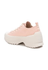 Scarpa da ginnastica in tela di un delicato colore rosa chiaro, con punta in gomma bianca e suola spessa in gomma. Presenta un tallone arrotondato e un pannello laterale testurizzato con un design angolare.