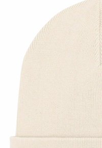 Gebreide muts in offwhite kleur, met een omgevouwen boord, een gladde textuur en een nauwsluitende afgeronde bovenkant. Zonder patronen of versieringen.