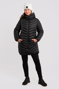 Abrigo de plumas negro con secciones acolchadas horizontales, un cuello alto y dos bolsillos laterales. Lleva puesto sobre pantalones negros y combina con zapatillas negras.