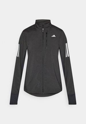 Veste de sport noire en matériau léger. Dotée d'une fermeture éclair sur le devant, d'un col haut et de trois rayures blanches sur chaque manche.
