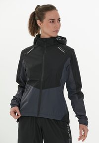 Vattentät jacka i svart och mörkgrå, med zippered framsida, justerbar huva och reflexer på axlarna.